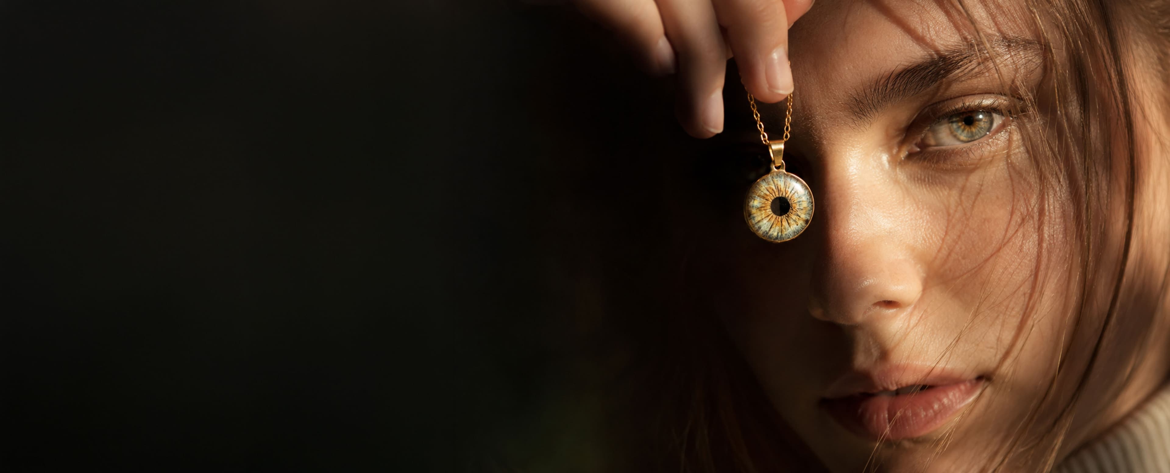 Persona mostrando un colgante personalizado con una fotografía de iris